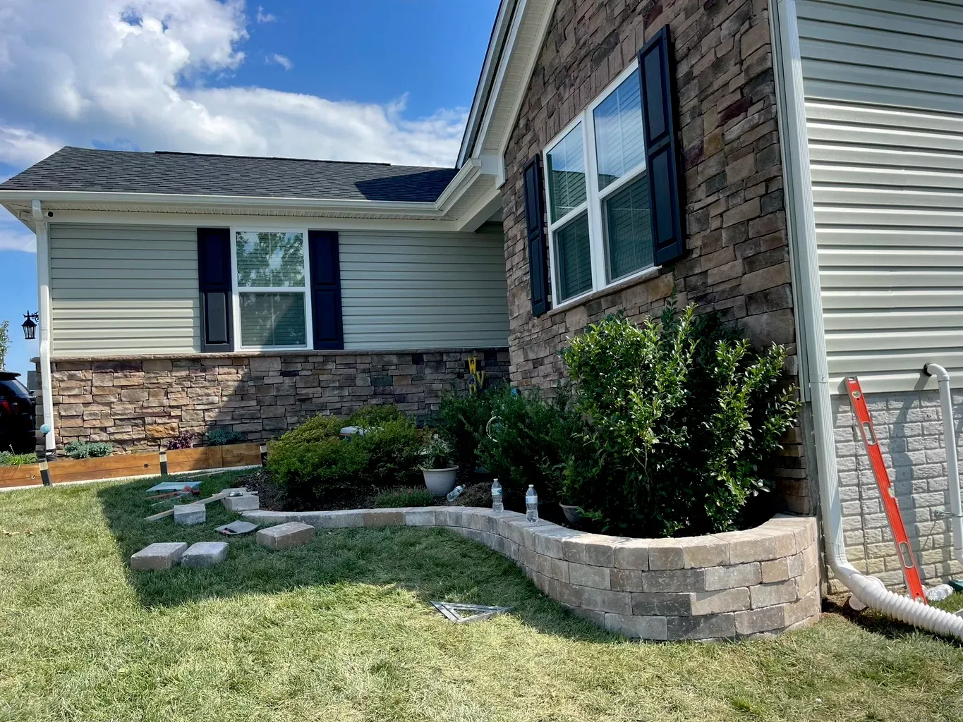 Residential exterior stone landscaping and curved masonry wall